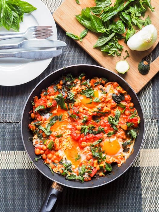 Shakshuka with Eggs, Tomatoes and Chickpeas with additional slivered basil to the side