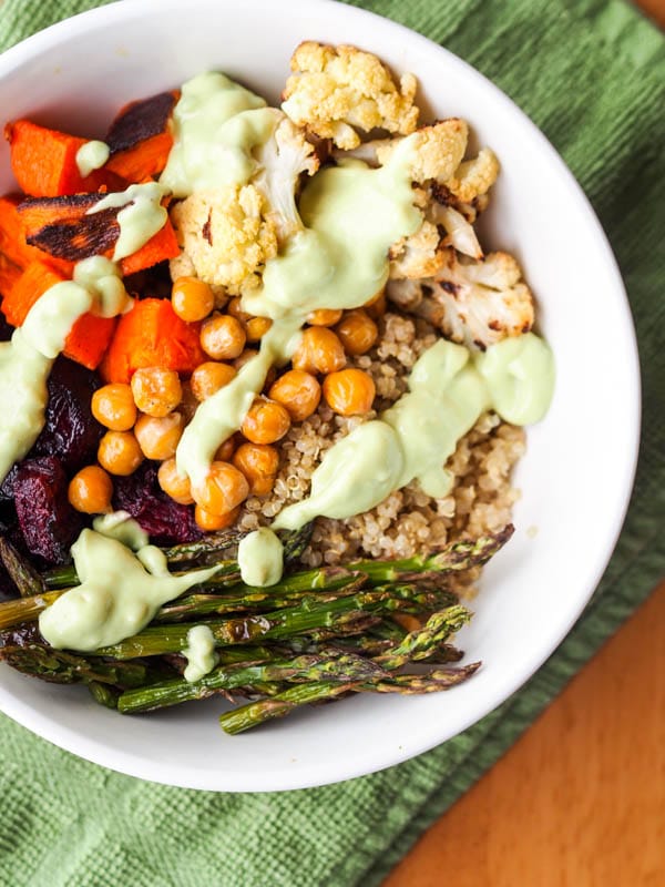 Vegan Quinoa bowl topped with roasted veggies and avocado sauce