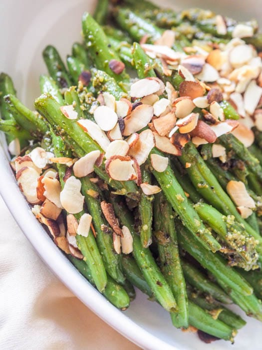 close up of plated green beans with sliced almonds sprinkled on top