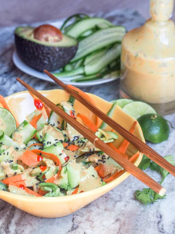 Vegan Asian carrot Salad made with cucumber ribbons, carrot ribbons, avocado ribbons, topped with a creamy ginger dressing and sesame seeds