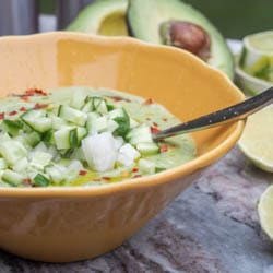 Super creamy and light vegan avocado gazpacho topped with diced onions, cucumbers and chili oil. Gluten Free, Made in minutes. | avocadopesto.com