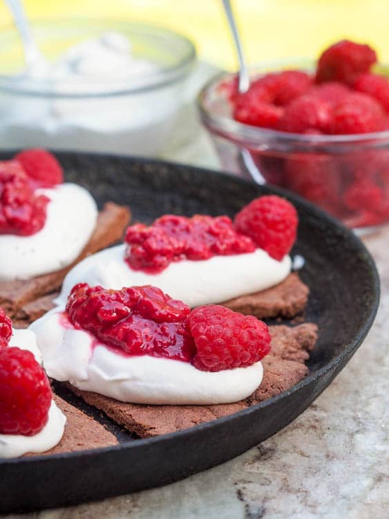 Dessert Pizza cut into slices  with whipped coconut cream and Raspberry Sauce 
