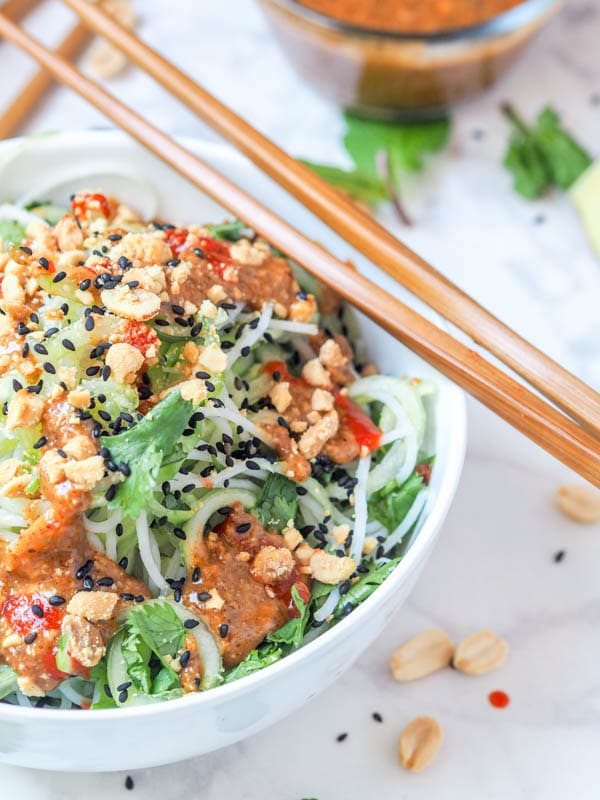 asian noodle salad topped with dressing 