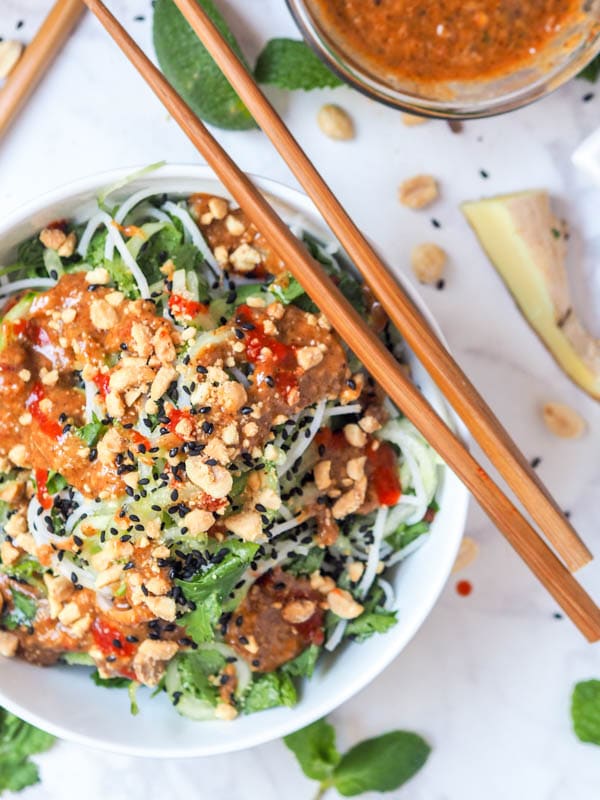 vegan asian noodle salad with dressing, sriracha and crushed peanuts 