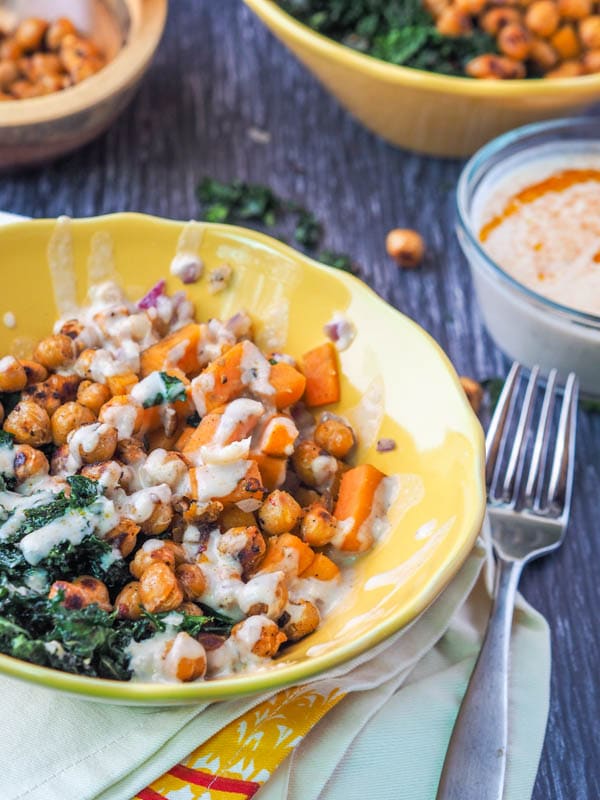 Vegan Power Bowl with Sweet Potatoes and Kale plated with dressing drizzled on top 