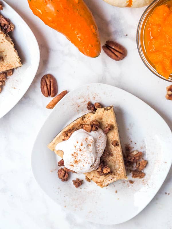 Fall vegan pumpkin cheesecake with coconut cream and candied pecans
