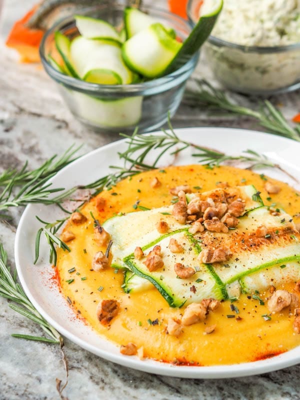 Zucchini ravioli plated on rosemary pumpkin puree and topped with crushed walnuts
