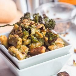 4 ingredient vegan and gluten free pumpkin gnocchi served with vegan basil pesto, oven roasted broccoli, brussels sprouts and pumpkin seeds. Perfect winter dinner.