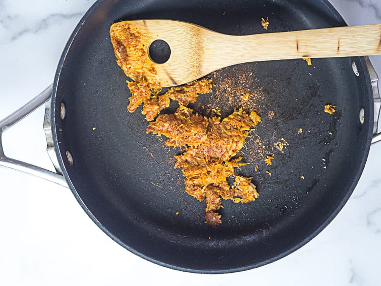 cooking red curry paste in a pan